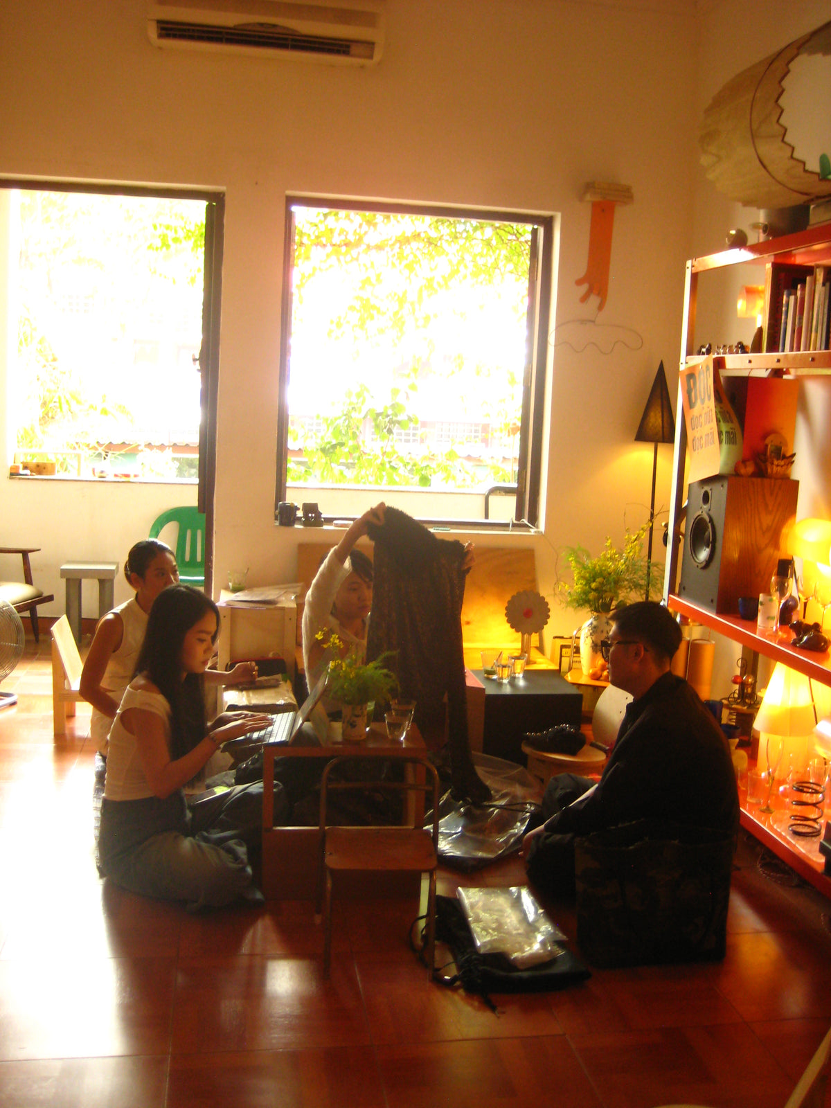 People standing in a room with large windows, sunlight streaming in