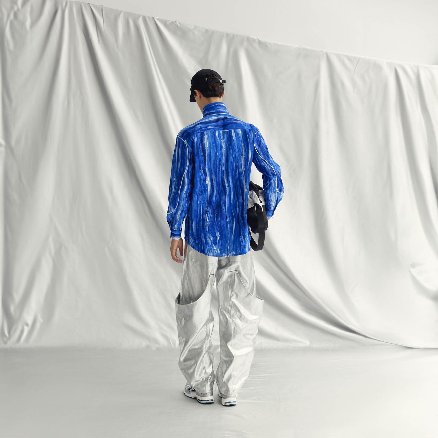 ARNE SHIRT | BLUE with band collar, buttoned cuffs, wide form, and metallic detailing from sleeves to chest.